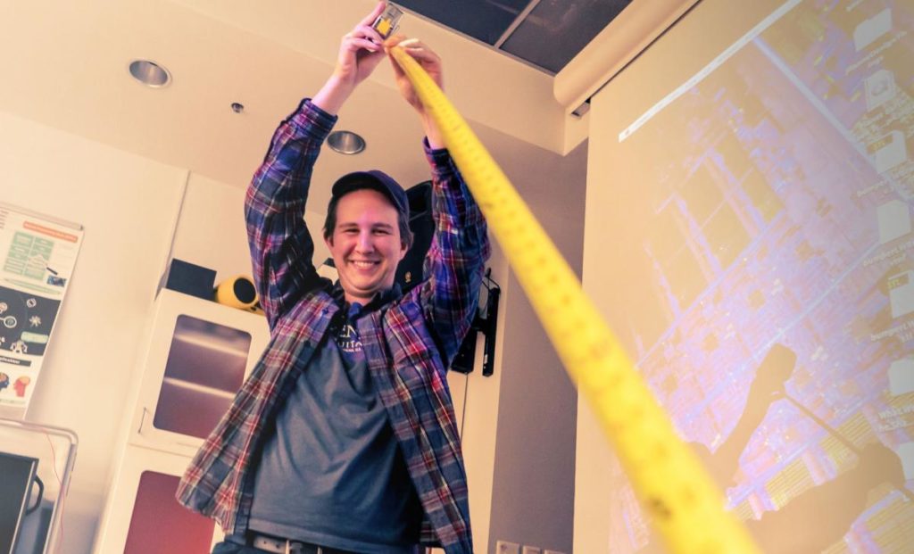 A student holding up a tape measure in the CCT studio