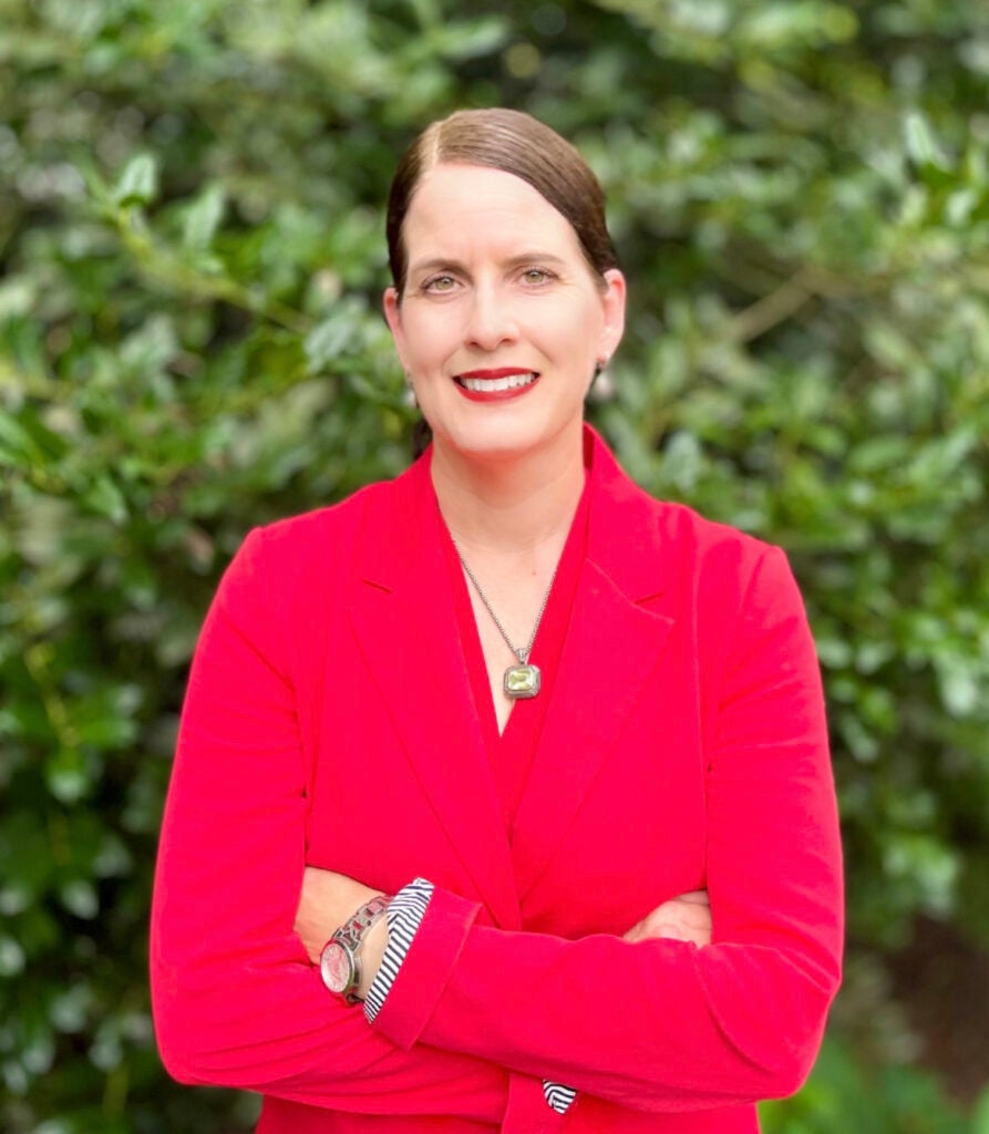 Laura DeNardis posing in a vibrant red jacket.