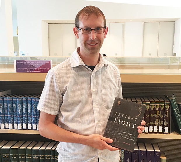 Professor JR Osborn holding his book Letters of Light at the Museum of Islamic Art in Doha