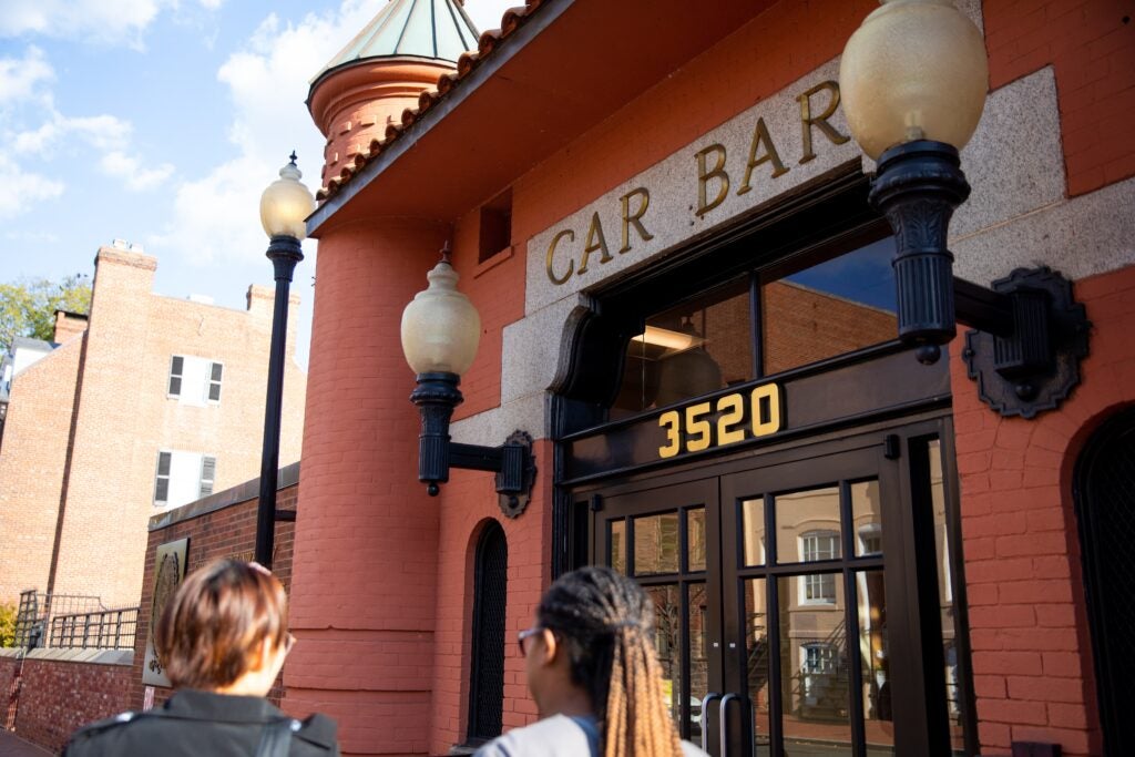 Exterior of the Car Barn building entrance. two students are walking towards the door.