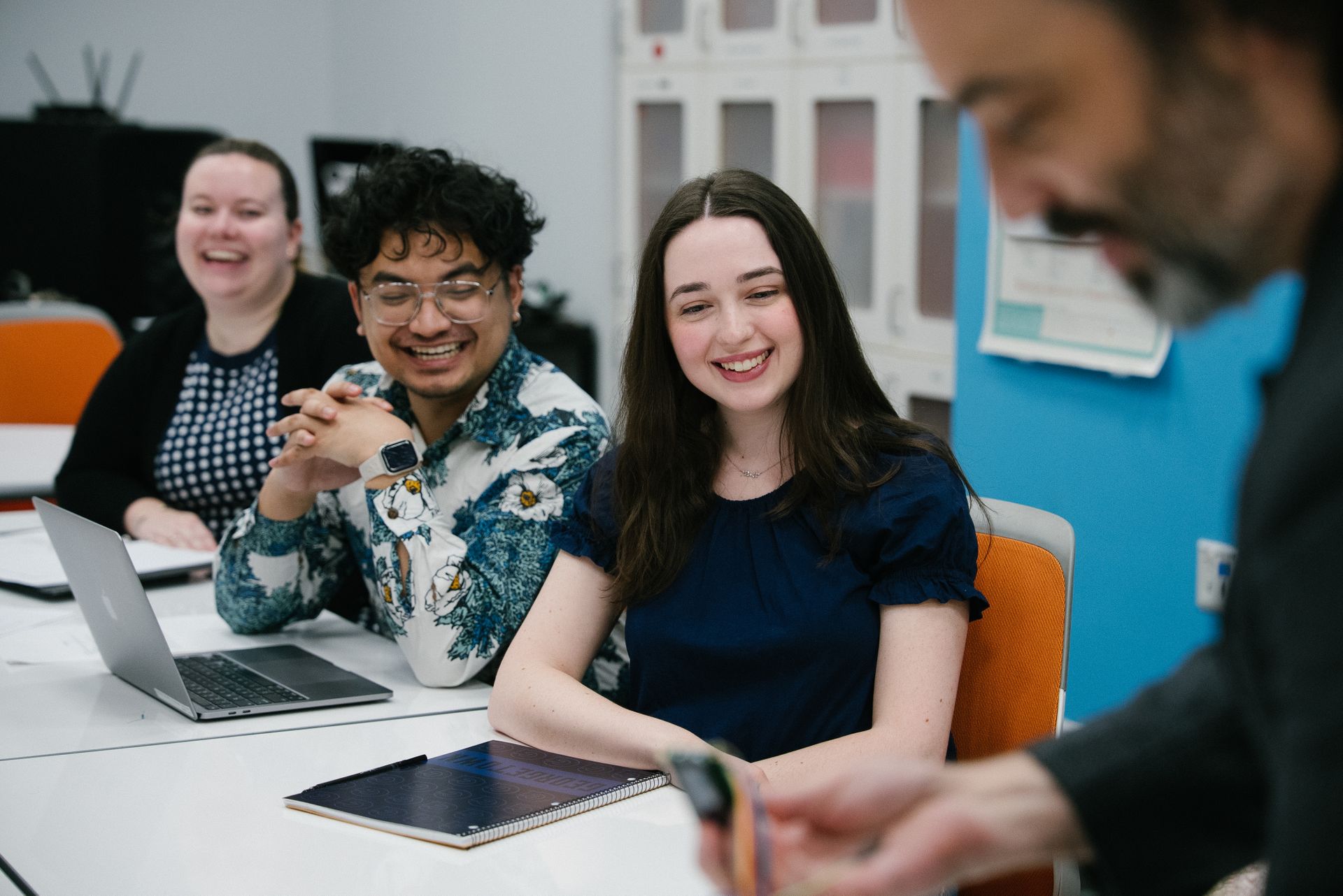 Three students watch a professor do a demonstration.