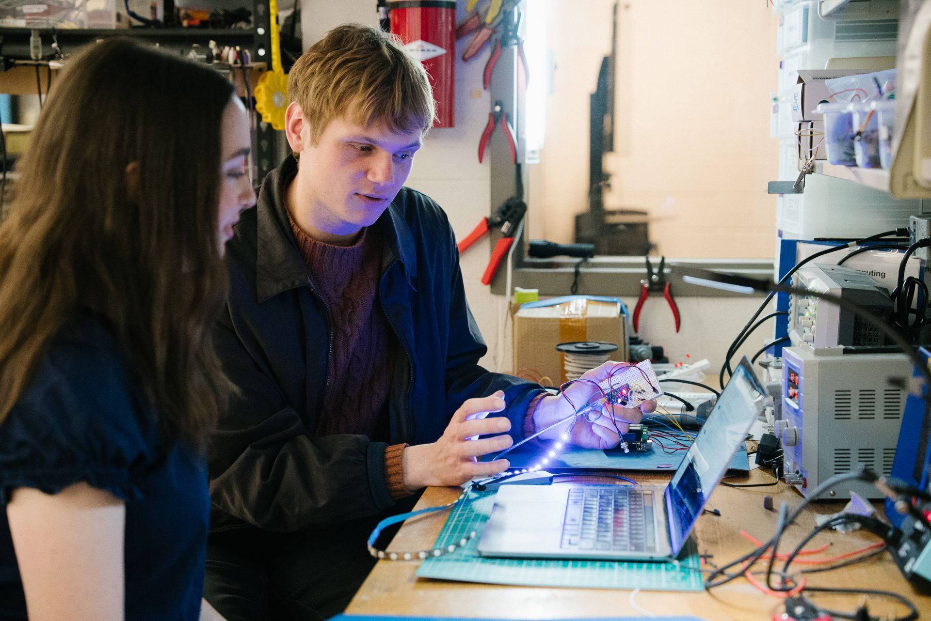 Two students look at a laptop together.