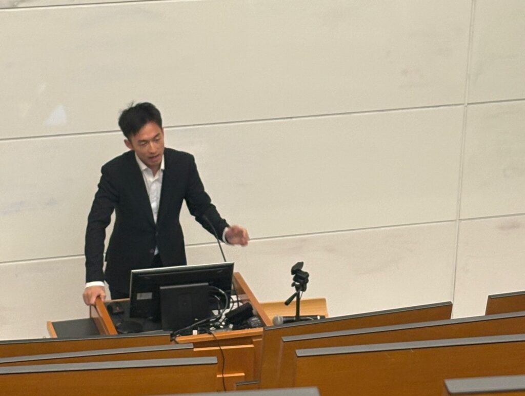 CCT second-year student, Iverson Yue, speaks at a presentation in an auditorium at Georgetown University.